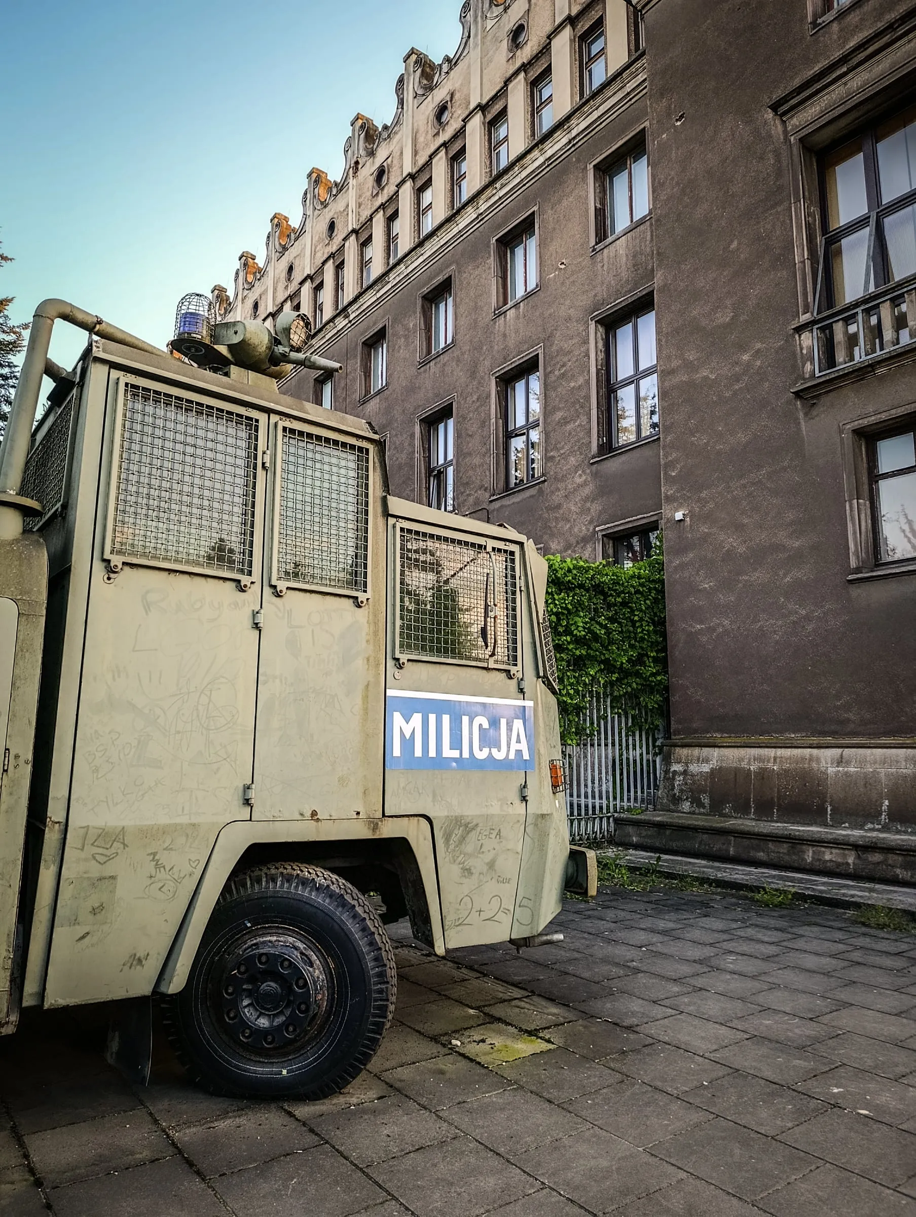 A Milicja riot water cannon truck, scratched with graffiti, parked by the steelworks Administrative Centre in Nowa Huta